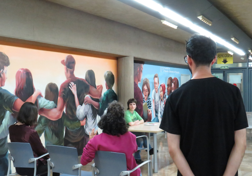 Persones participant en el taller de teatre a la sala dels murals de la Facultat de Filosofia i Ciències de l'Educació